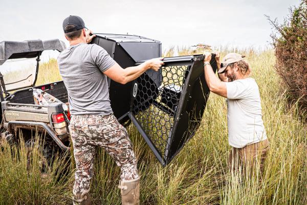 orion hunting feeder being unloaded by two men 