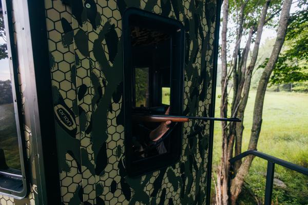 Gun aiming out a blind
