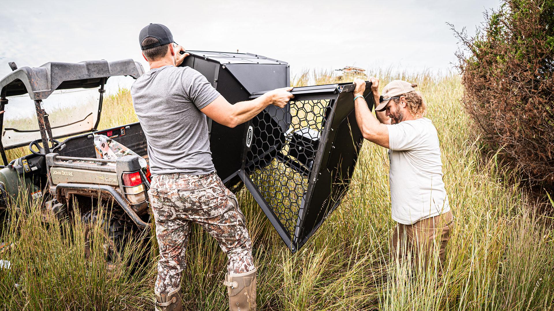 orion hunting feeder being unloaded by two men 