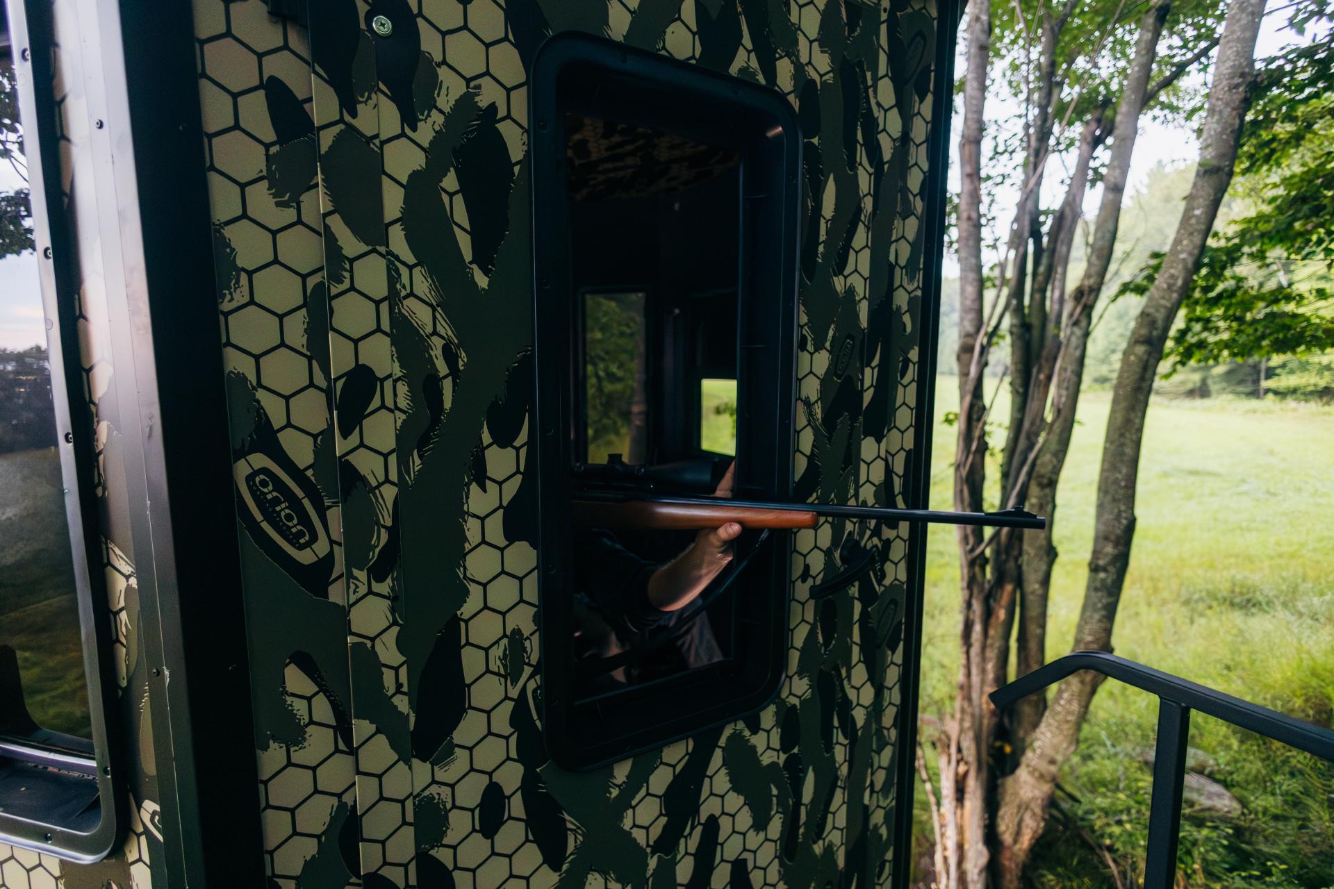 Gun aiming out a blind